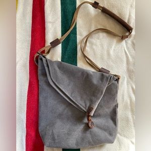 Canvas and leather fold-over crossbody satchel with several zipper pockets